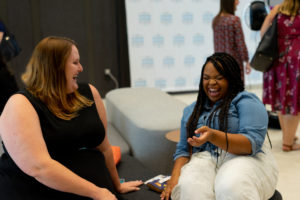 Two JLA members laugh together in a candid shot.