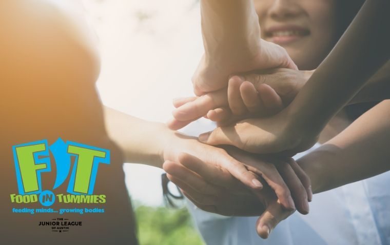 Women's hands stack in a gesture of teamwork. Food in Tummies logo attached.