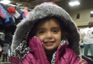 Young girl wearing puffy, pink coat at Coats for Kids