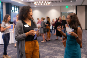 Two women visit and laugh at an admissions event